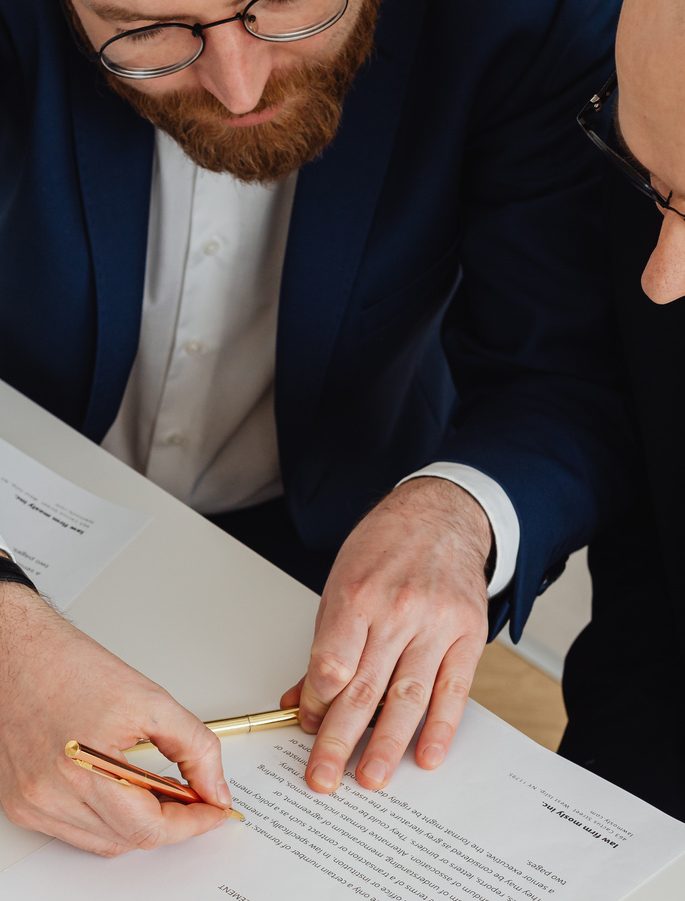 Directivo firmando un documento sobre una mesa de trabajo